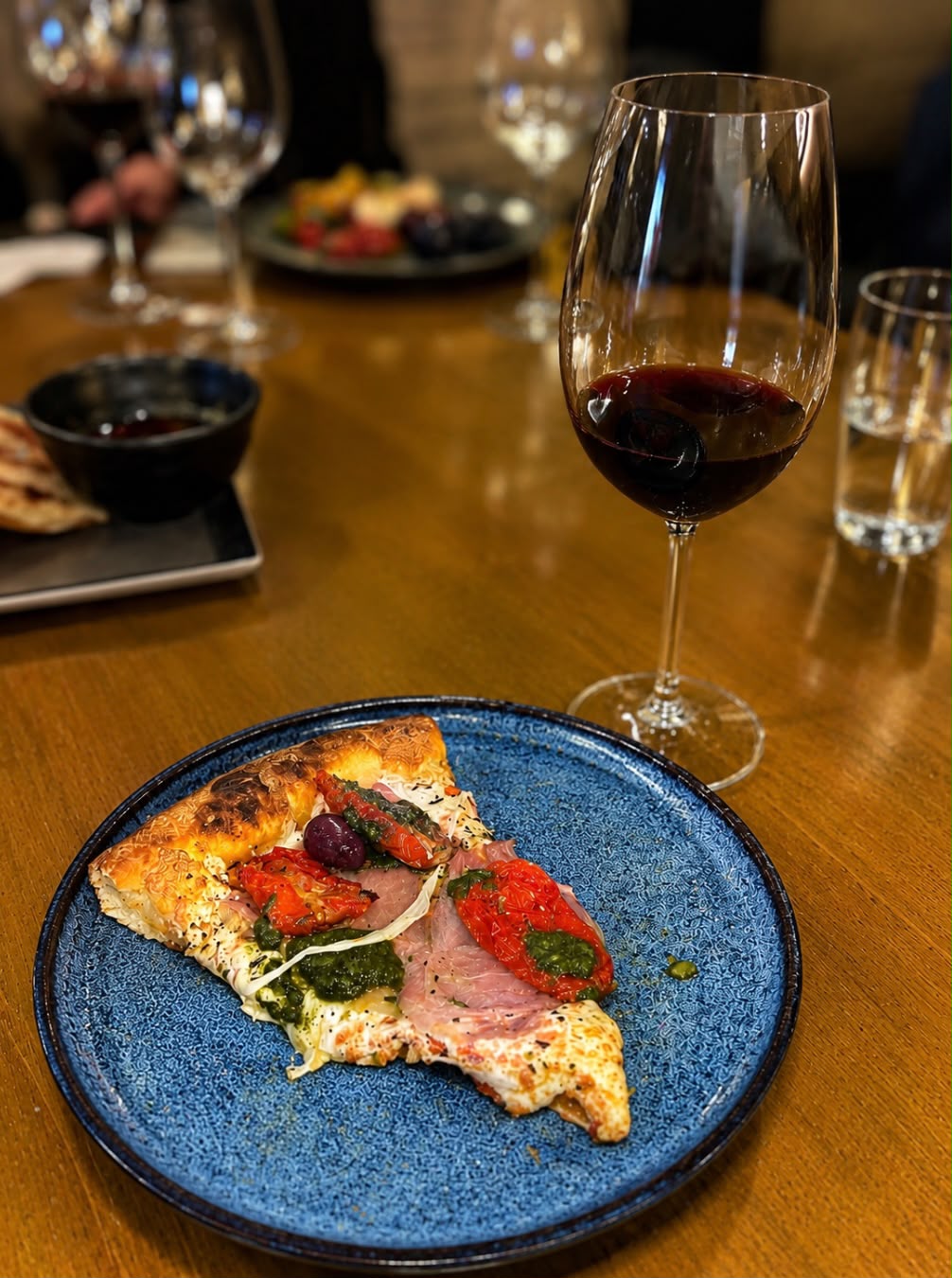 Taça de vinho e pizza durante noite de harmonização em São José dos Campos